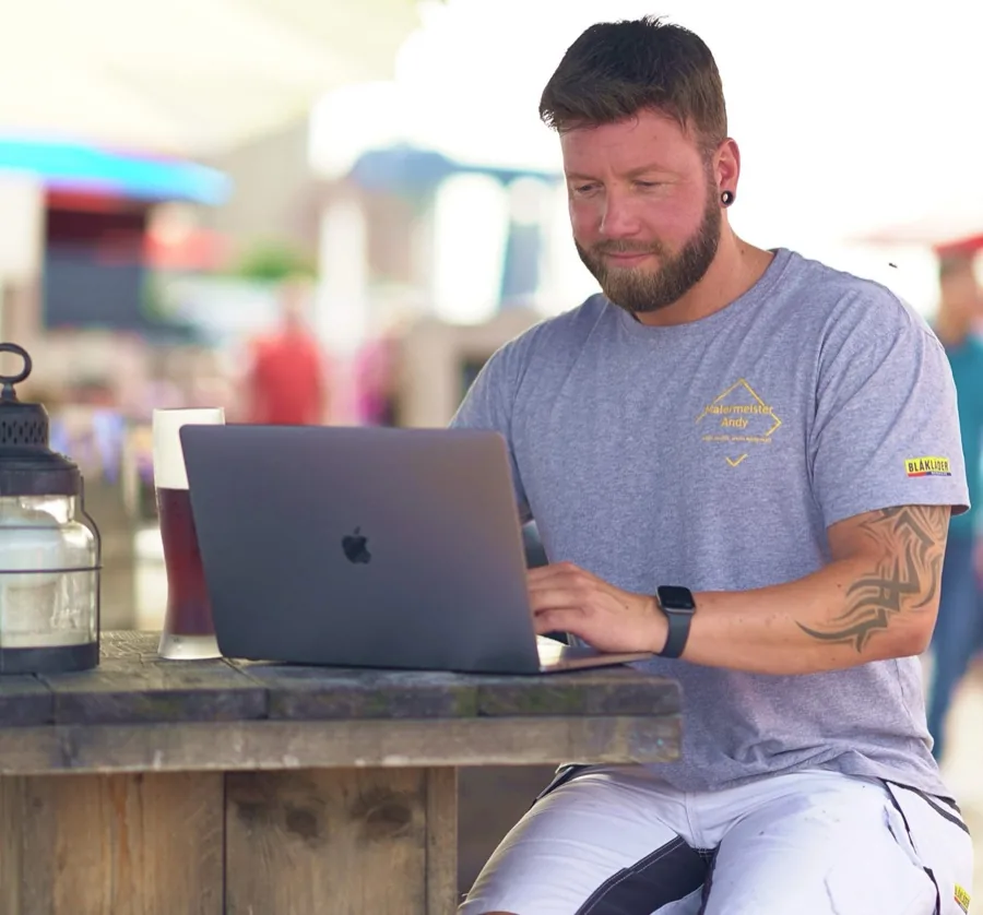 Andy Hansen arbeitet draußen am Laptop – Planung und Beratung