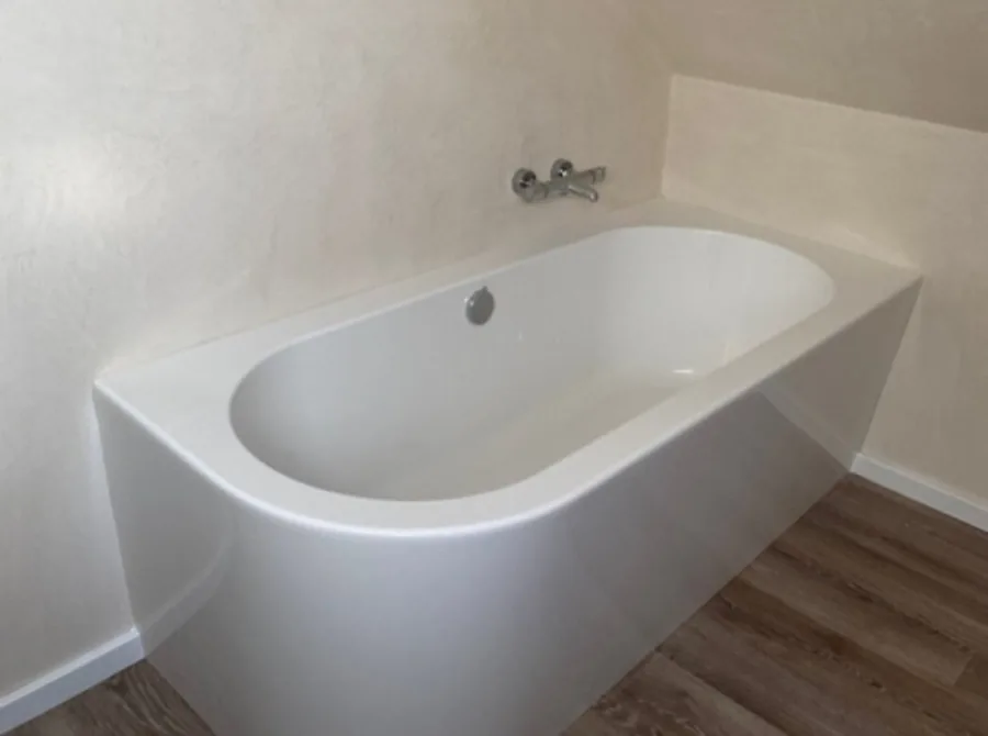 Badewanne vor fugenloser, gespachtelter Wand – fugenlose Oberflächen im Bad